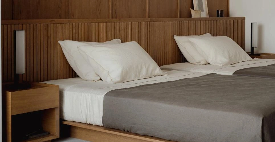 Two beds arranged side-by-side in a small college apartment bedroom.