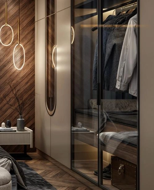 Small bedroom with transparent wardrobe doors showing neatly arranged clothing, creating an open and airy feel.
