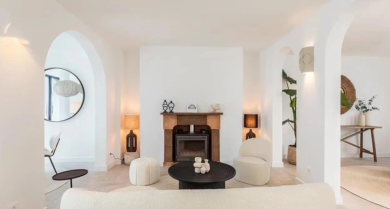 White arched partition dividing spaces in a small apartment.