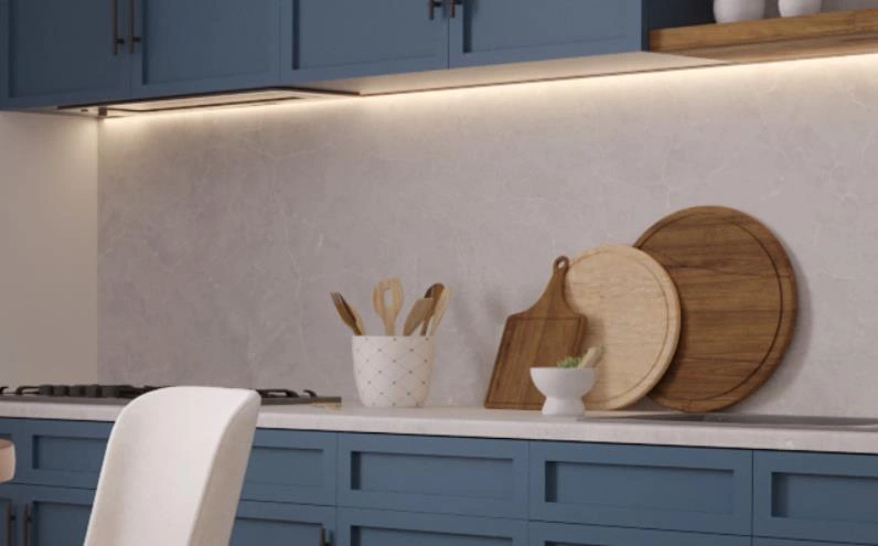 Tiny kitchen idea with a warm under-cabinet LED light strip illuminating gray walls and countertops.