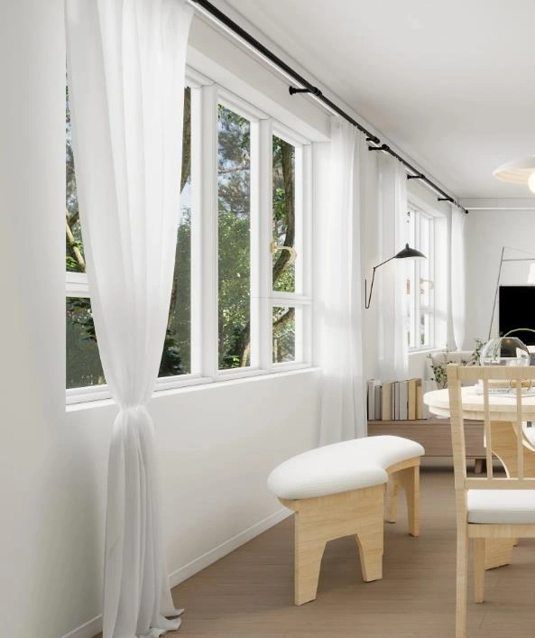 White sheer curtains on a black rod brighten the living room with soft natural light.