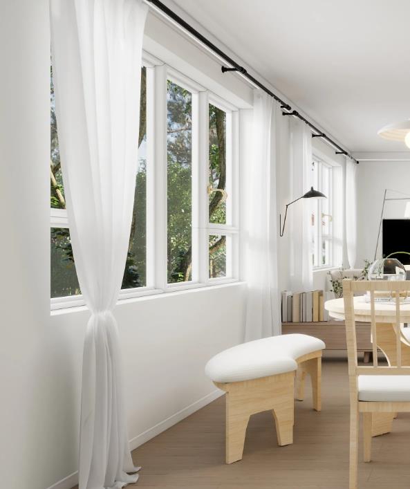 White sheer curtains on a black rod brighten the living room with soft natural light.