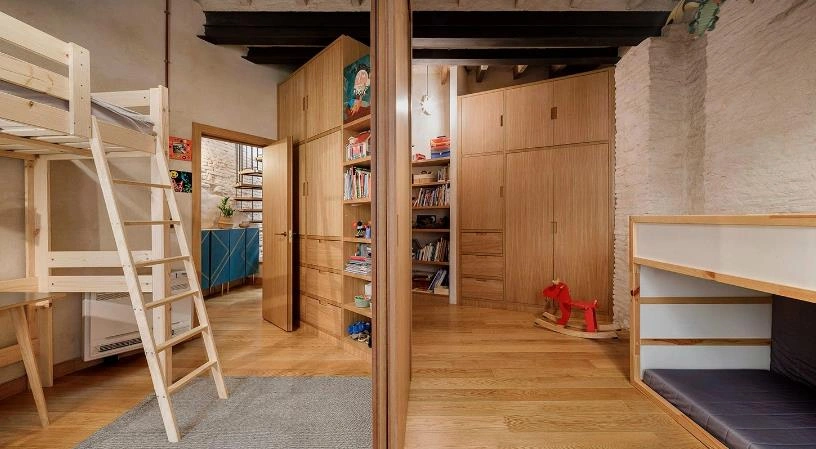 Wooden sliding-door semi-enclosed layout dividing zones in a small apartment.