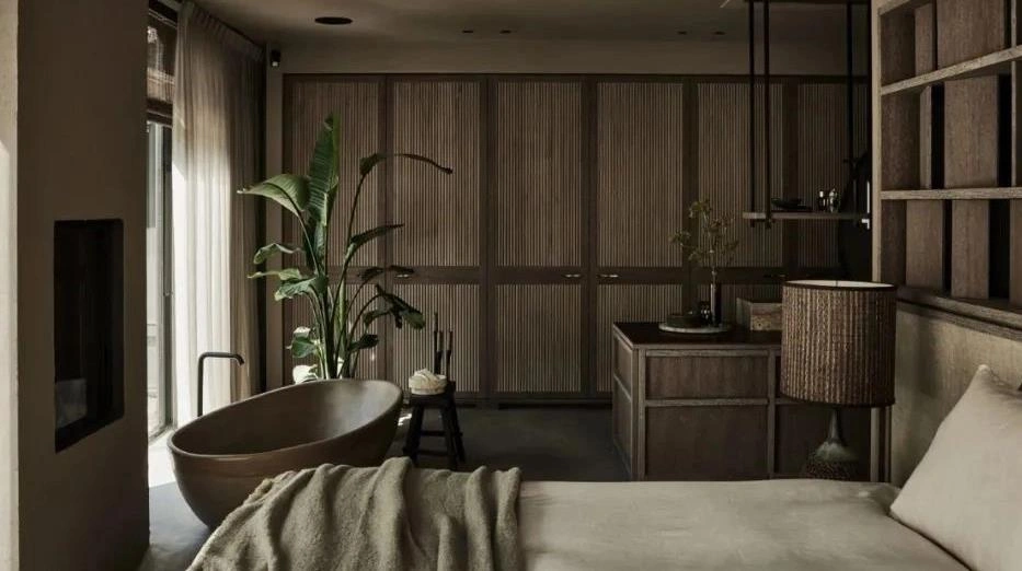 Freestanding mini bathtub placed inside a small apartment bedroom.