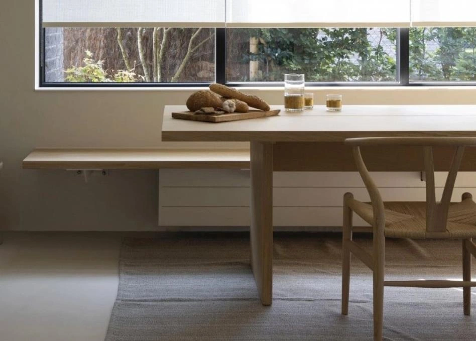 Compact light-wood dining table for one in a studio apartment.