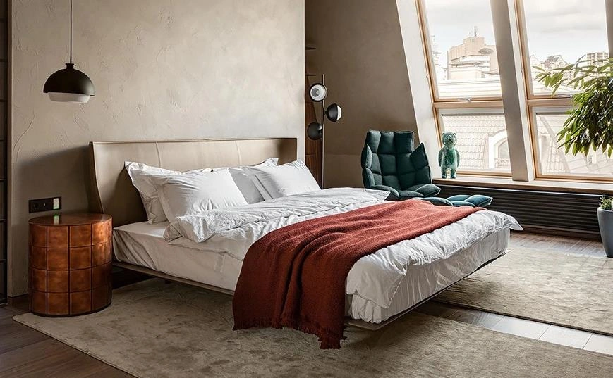 Pair of long beige rugs placed beside the bed in a small apartment bedroom.