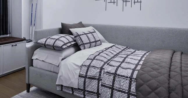 Compact bedroom with a gray single sofa bed and black-and-white checkered bedding for a practical and cozy layout.