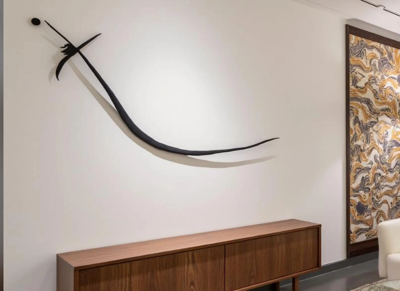 Large black metal three-dimensional wall decor in a small bedroom.