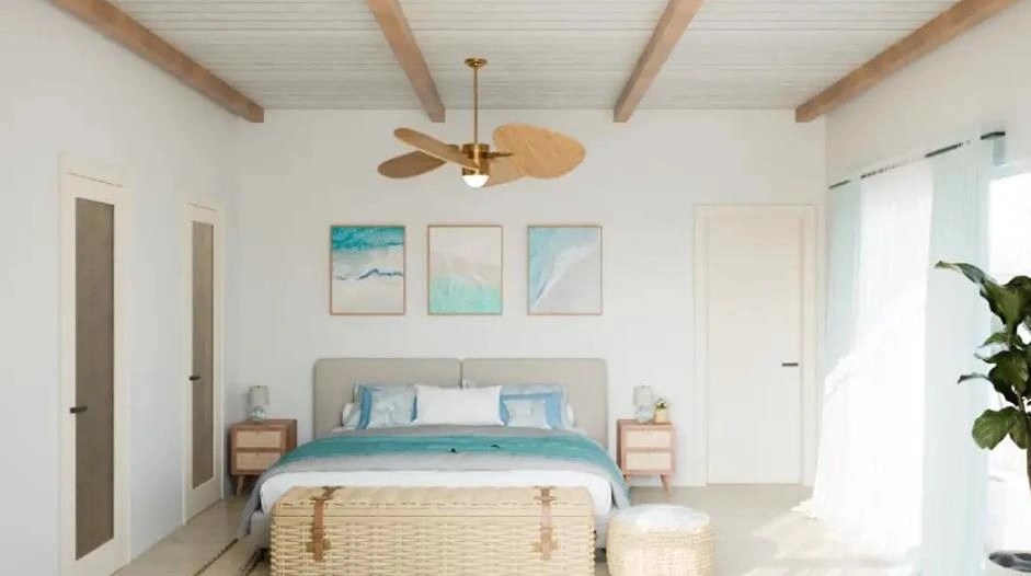 A modern coastal master bedroom with a wooden fan, ocean artwork, and blue bedding
