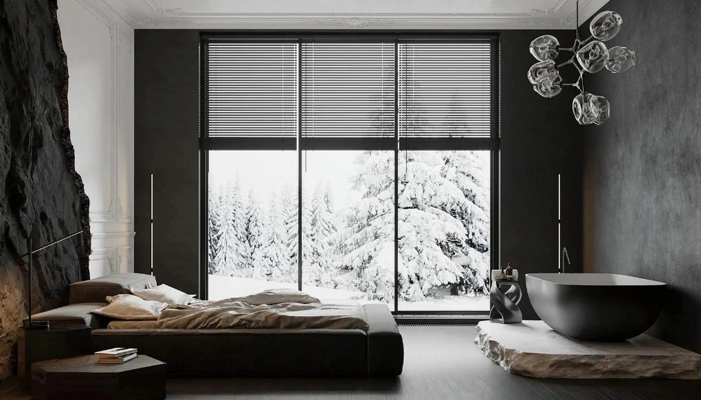 A dark dramatic master bedroom with warm lighting and a bathtub near the bed