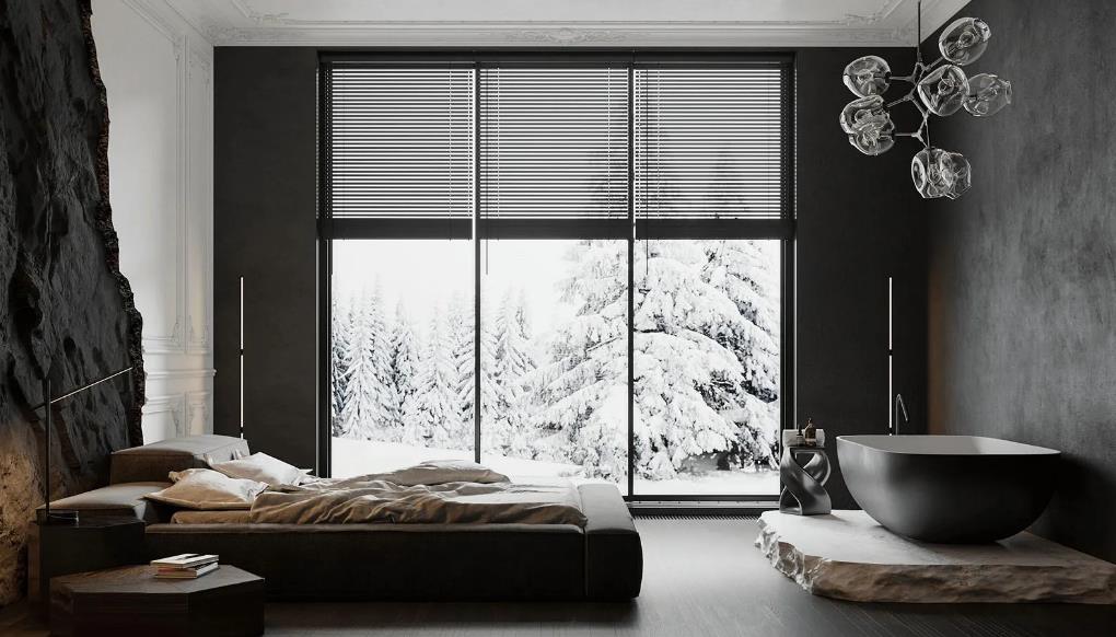 A dark dramatic master bedroom with warm lighting and a bathtub near the bed